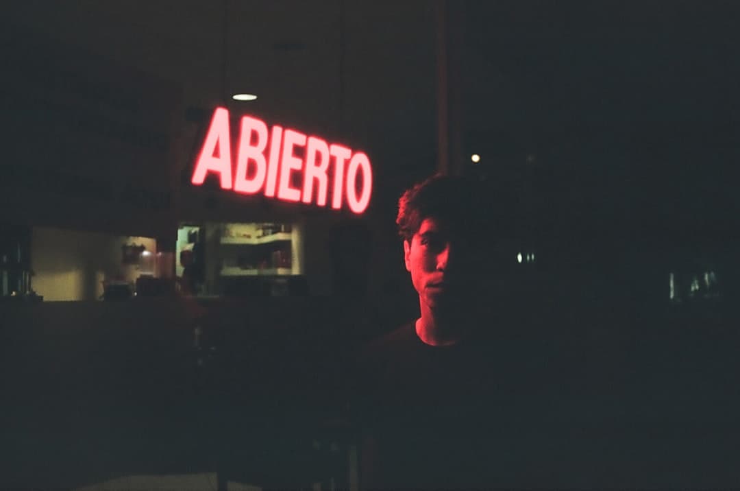 A man standing in front of a neon sign