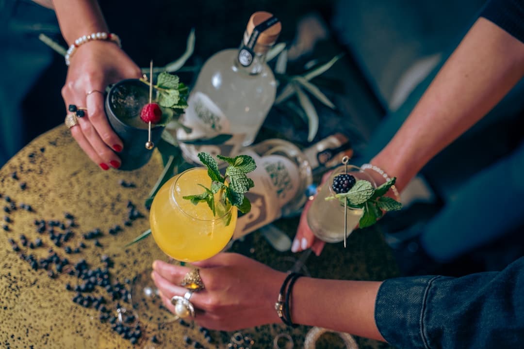 a group of people standing around a table with drinks