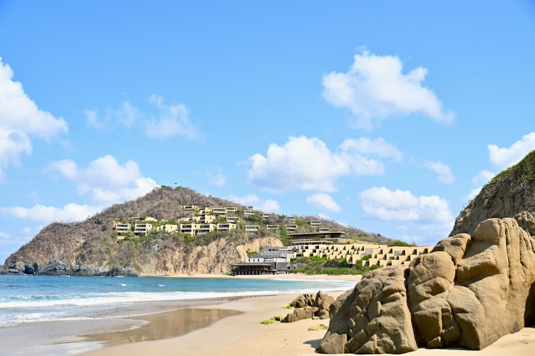 Rocky beach with resort buildings on a sunny day