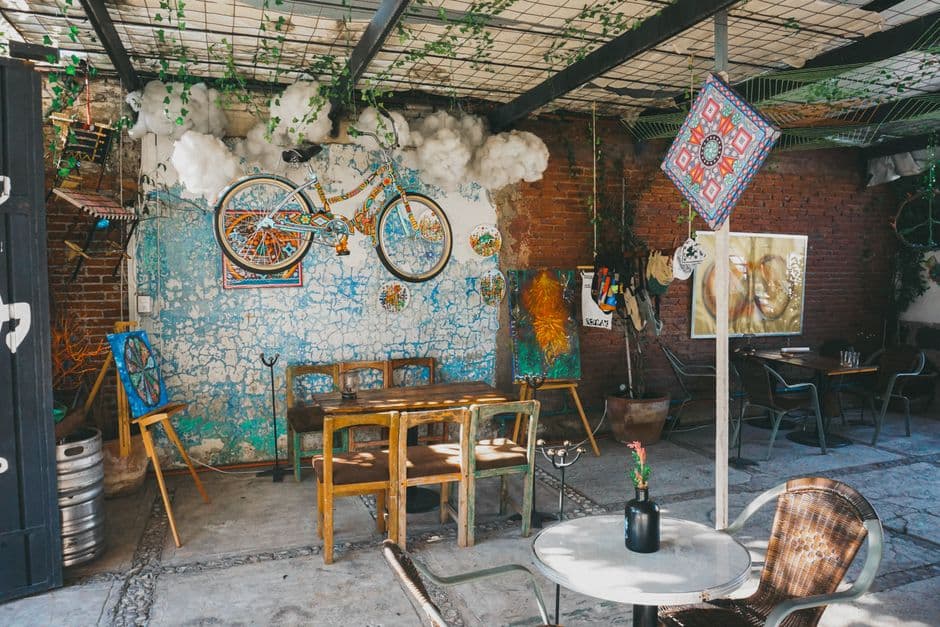 Eclectic cafe with colorful decor, mural art, and unique bicycle installation.