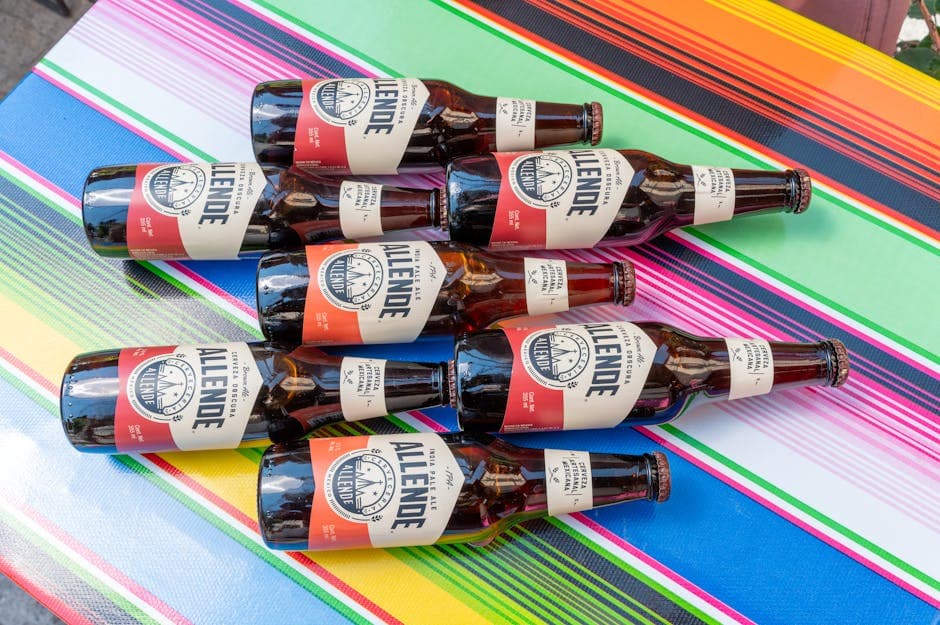 A collection of craft beer bottles arranged on a colorful Mexican tablecloth, perfect for cultural and beverage themes.