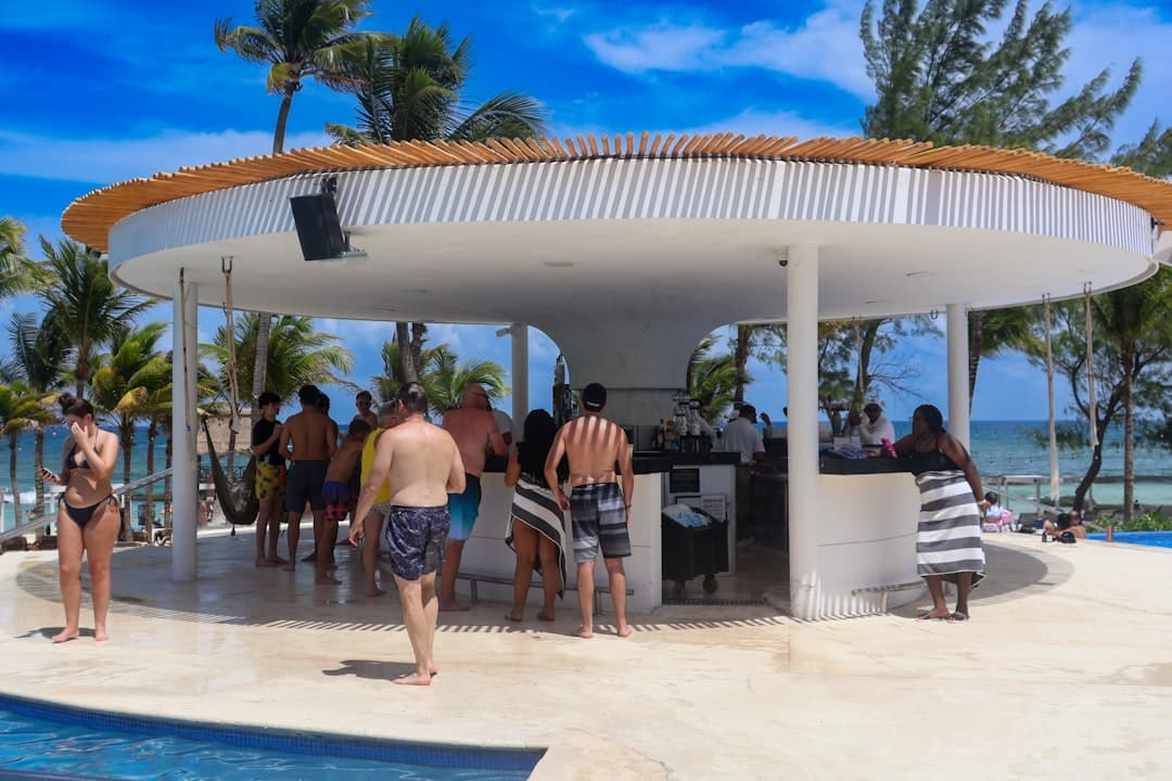 A group of people standing around a swimming pool