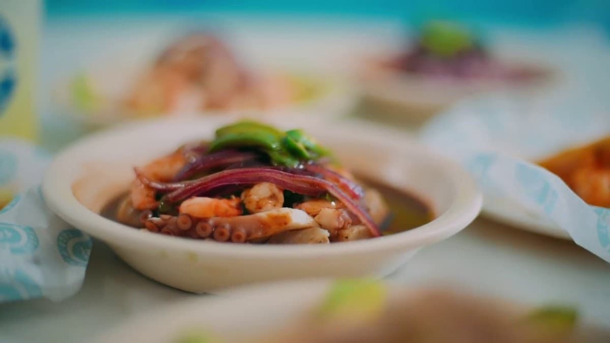 Fullenio's Taco Fish – foto del ceviche de camarón en plato blanco, con cubitos de limón y cilantro, tomada dentro del local mostrando la barra de salsas