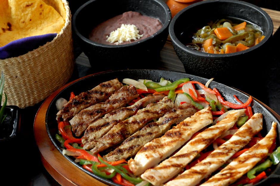 Delicious fajitas with grilled meats and Mexican sides in vibrant presentation.