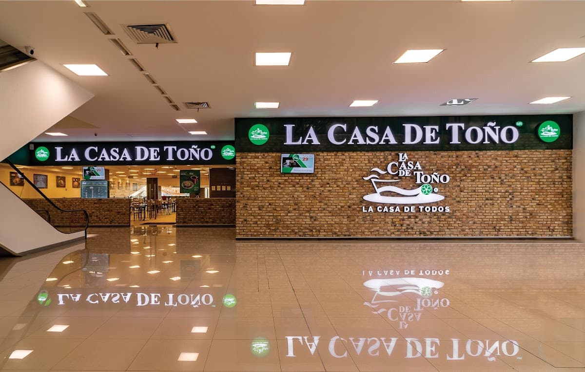 Exterior colorido de La Casa de Toño en Plaza Chimalhuacán con clientes en fila y el letrero tradicional
