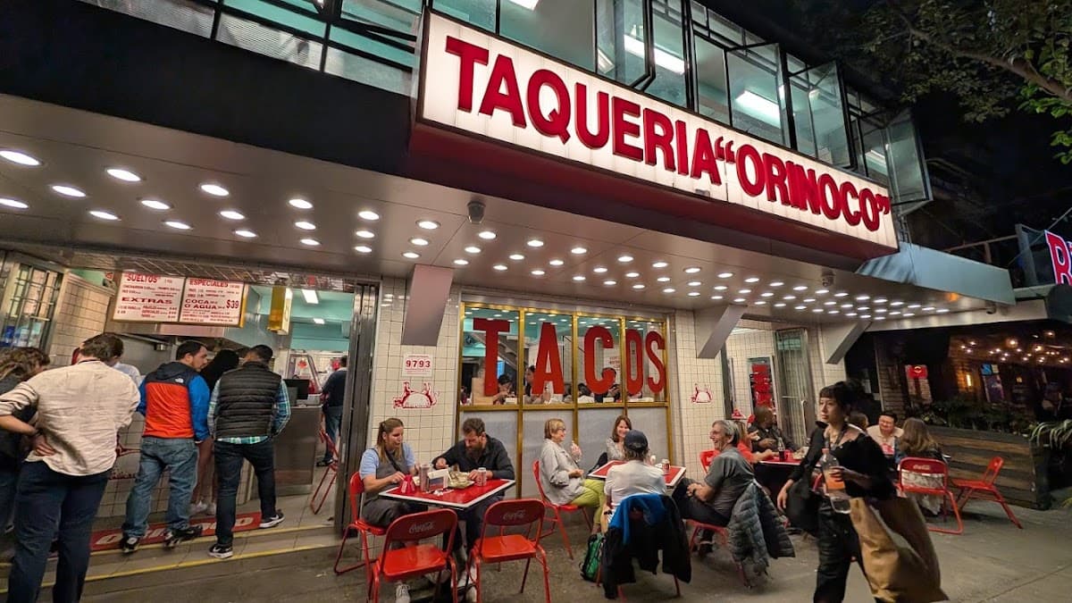 Fachada de Taquería Orinoco en Av. Álvaro Obregón, con su letrero rojo y clientes formando fila en la acera