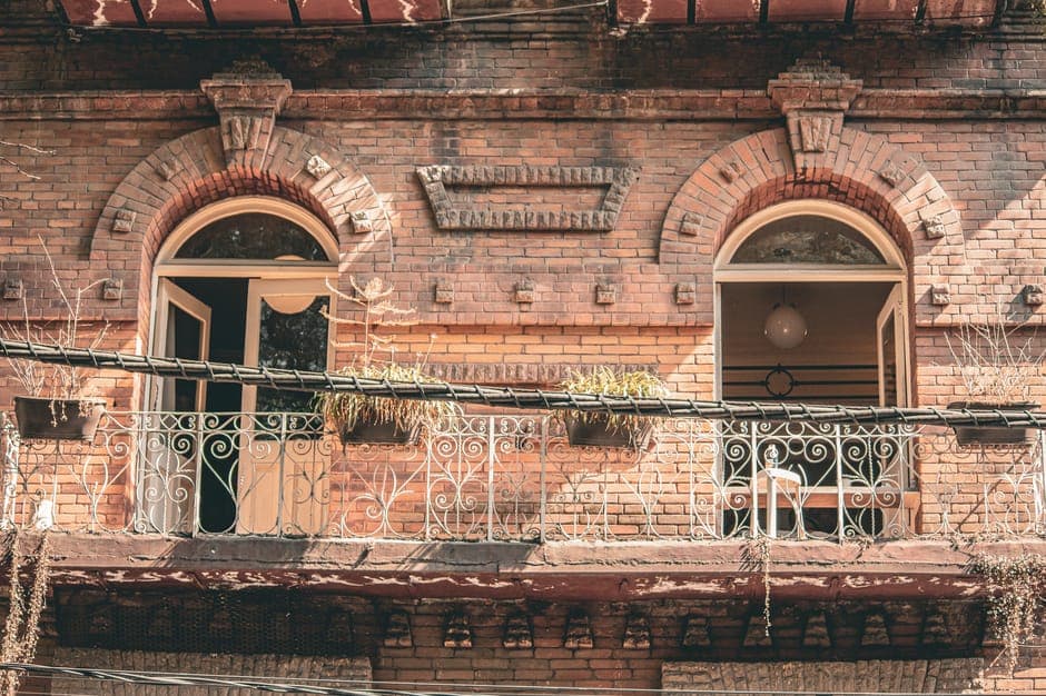 A charming historic brick facade with ornate iron balconies in Ciudad de México, capturing urban architecture.