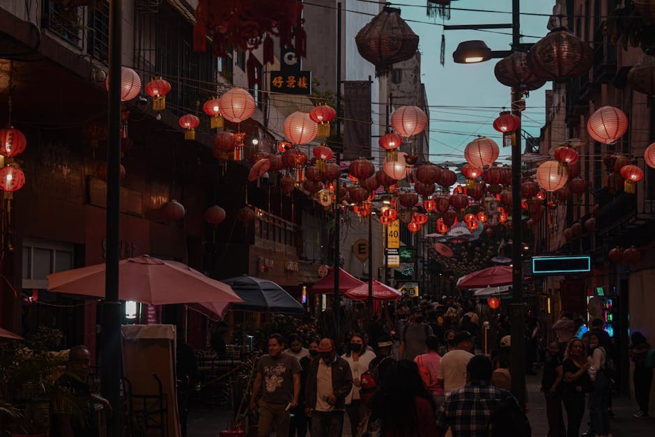 Bustling street in Ciudad de México with Chinese lanterns illuminating the evening scene, creating a vibrant atmosphere.