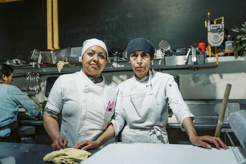 Two skilled chefs in a Mexican restaurant kitchen, showcasing teamwork and culinary expertise.