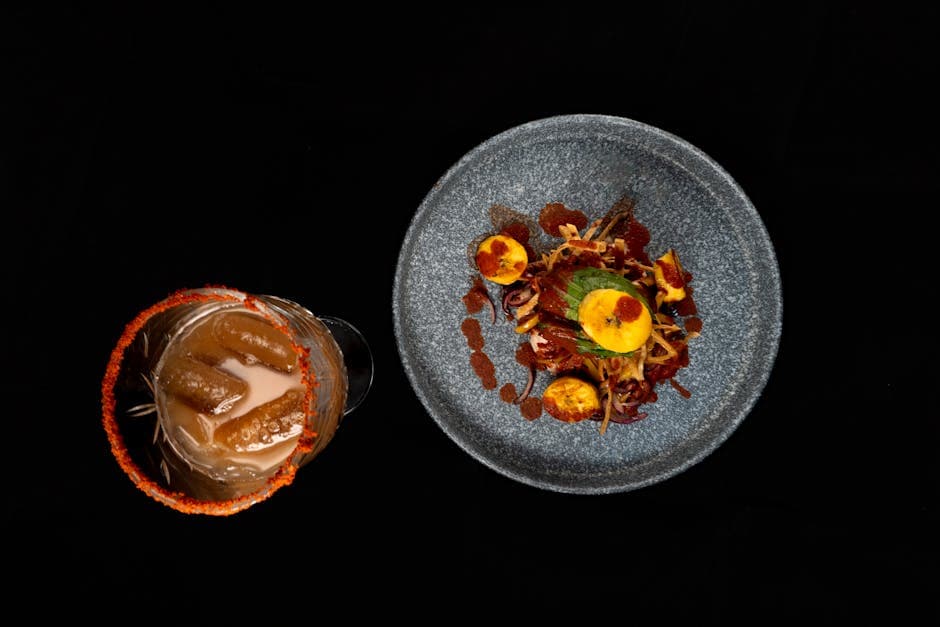 Top-down view of a gourmet Mexican dish with a tamarind-infused drink, showcasing vibrant culinary artistry.