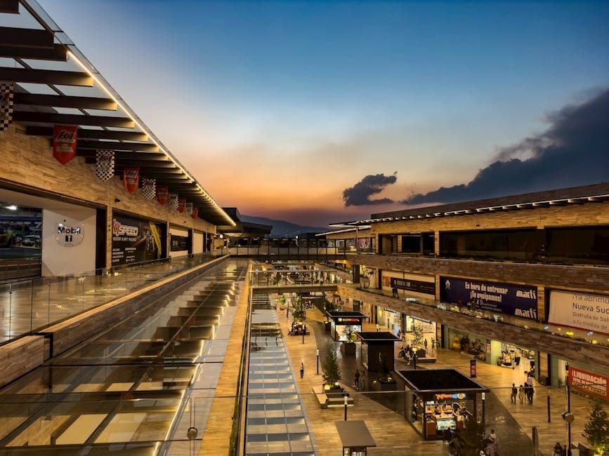 A modern shopping mall in Mexico City under a stunning sunset sky, showcasing vibrant urban life.