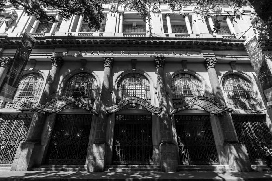 Black and white view of Teatro de la Ciudad in Mexico City highlighting architectural details and shadows.