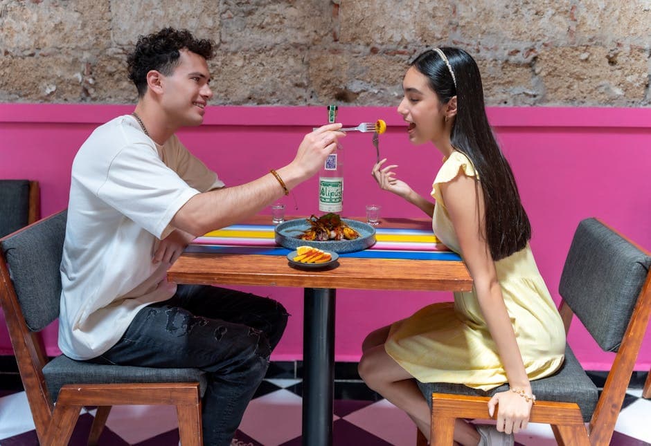 A happy couple sharing food at a vibrant restaurant in Mexico City, enjoying a romantic moment.
