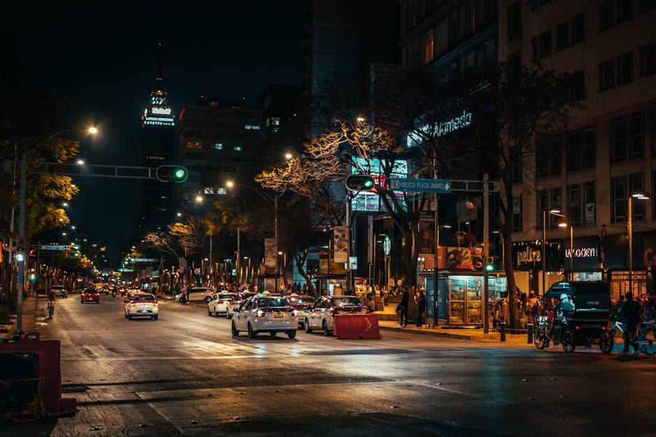Explore the lively evening scene of Mexico City with bustling streets and colorful lights.