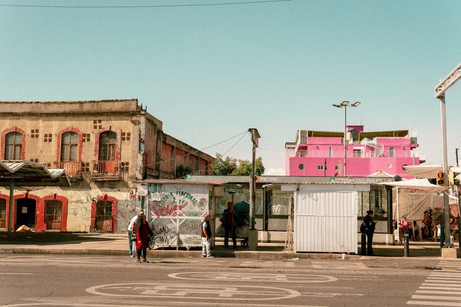 Bus stop scene with colorful buildings in Ciudad de México, showcasing local urban life.