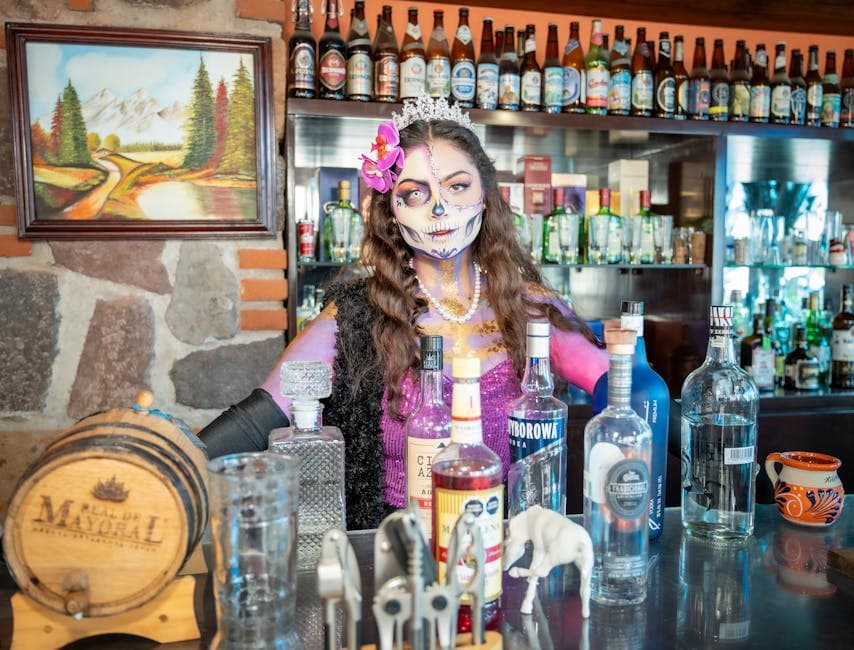 A striking Catrina figure behind a well-stocked bar in Ciudad de México, highlighting Mexican culture.