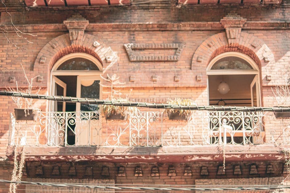 Vintage-style balcony on a brick building in Mexico City, capturing classic architecture.
