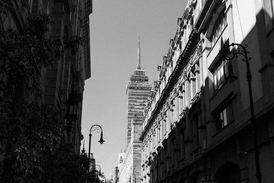 Black and white photo of Torre Latinoamericana in Mexico City's urban landscape.