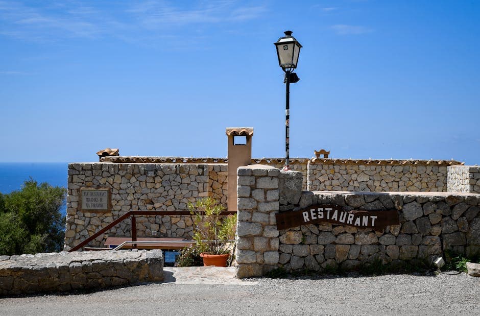 A scenic Mediterranean restaurant in the Balearic Islands with stunning stonework and ocean views.