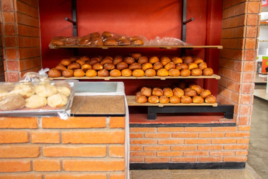 A vibrant display of fresh Mexican bread in a brick-walled bakery. Perfect for culinary and cultural themes.