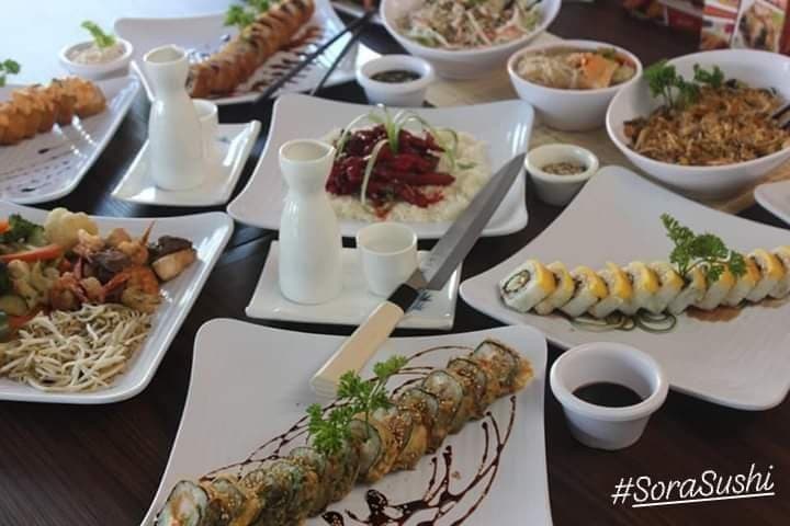 Taikai Victoria mostrando su barra de sushi con platos coloridos y clientes disfrutando el ambiente