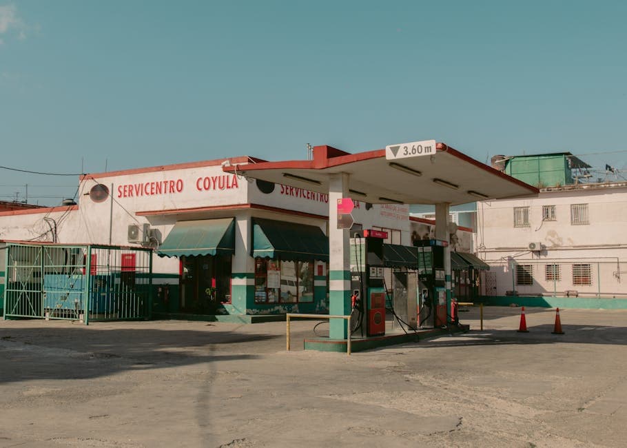Old-fashioned gas station structure under a clear blue sky in daylight.