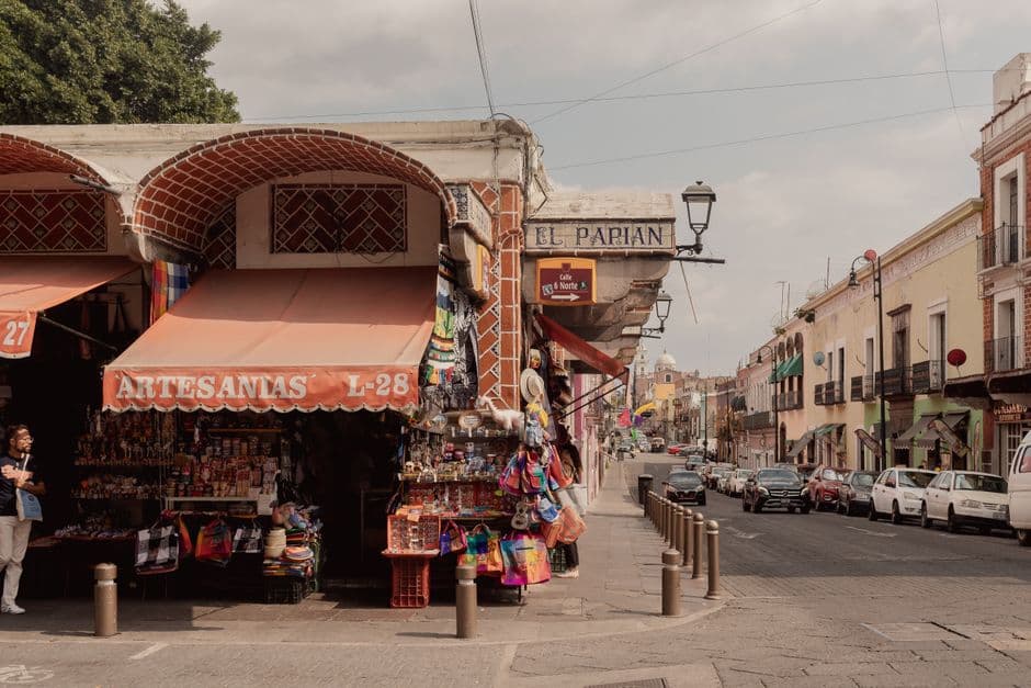 Charming street view of El Parián market, Puebla City, showcasing local crafts and vibrant shop displays.