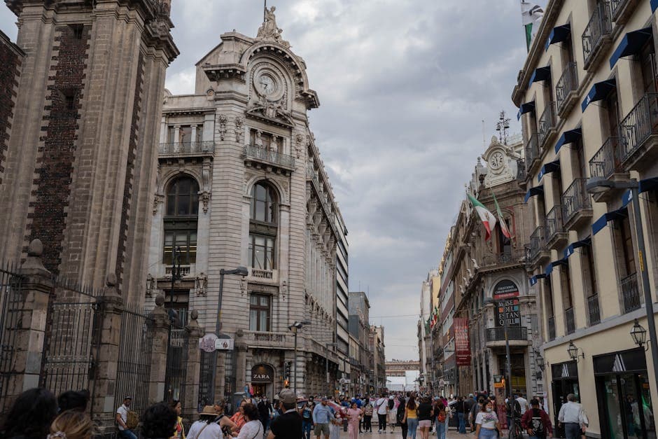 Vibrant scene of historic buildings and bustling crowd on Madero Street in Mexico City.
