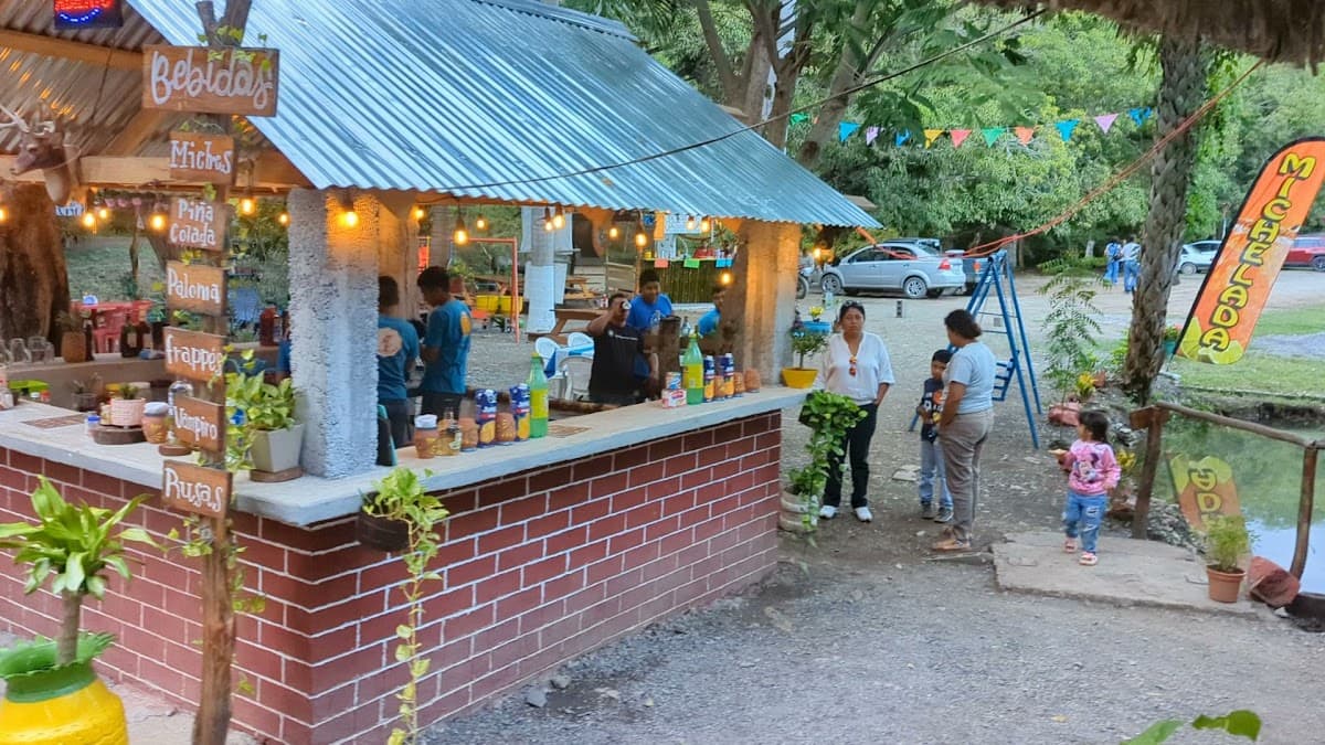 Vista exterior de Reserva de la Biósfera El Cielo con su jardín junto al río y una mesa puesta para cena