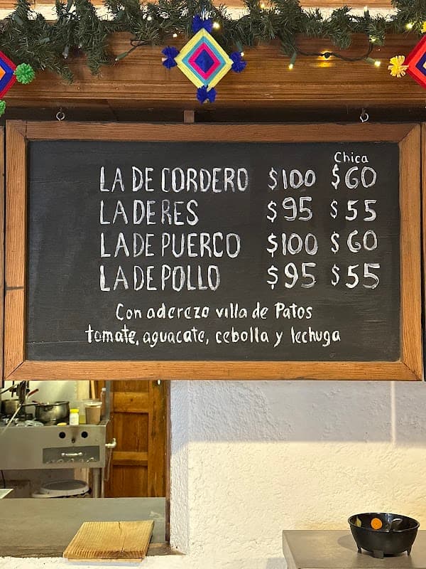 Mostrando la fachada de Super Boxxo con su letrero y una vitrina llena de carnes y embutidos.