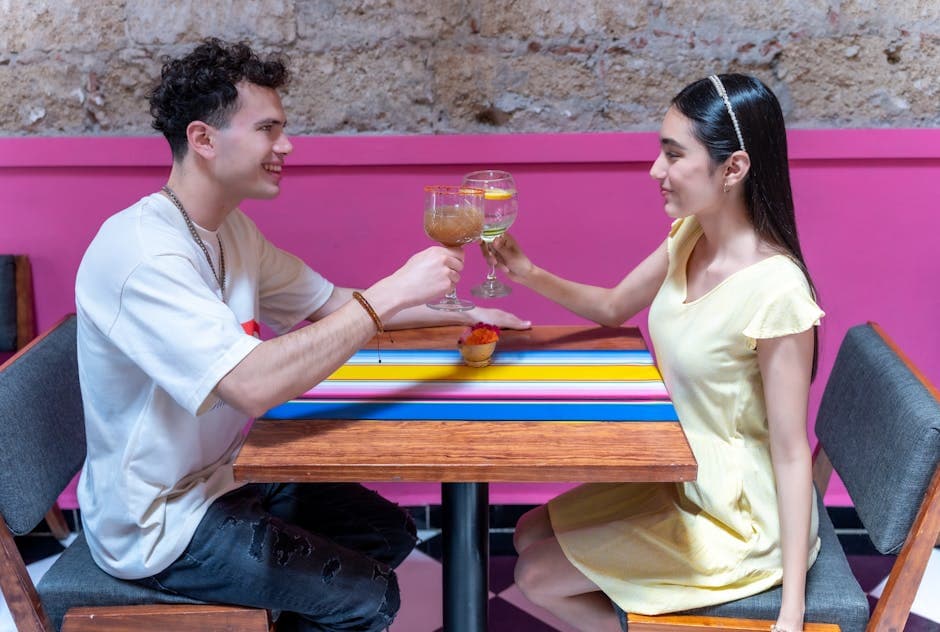 Happy couple toasting with cocktails at a colorful restaurant in CDMX, Mexico.