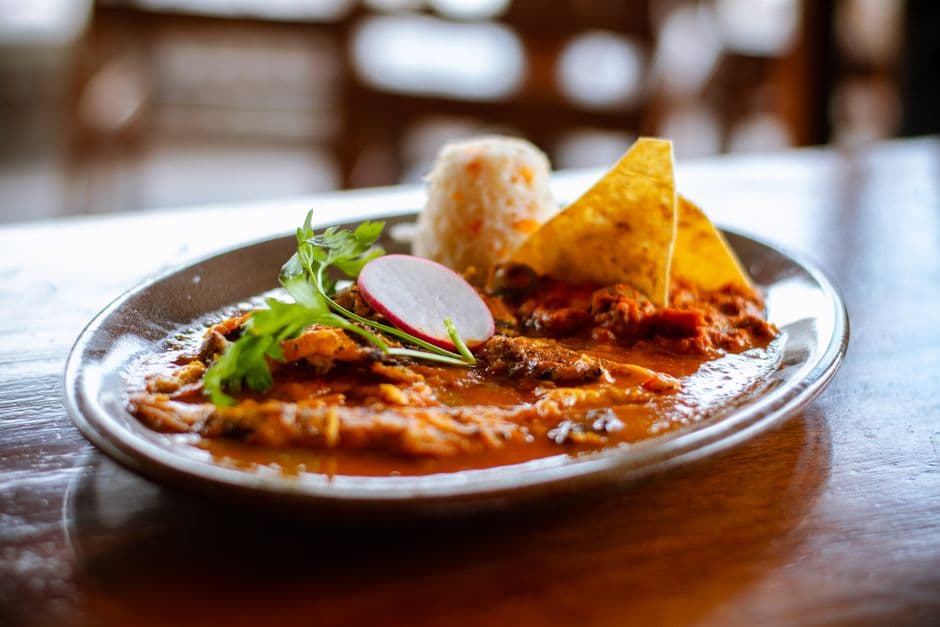 Close-up of a Mexican meal featuring rice, tortilla chips, and spicy sauce, perfect for cuisine lovers.