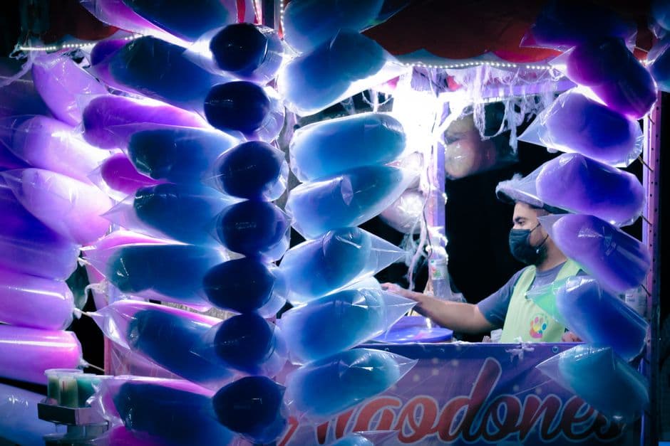 Colorful cotton candy stall at night in León de los Aldama, capturing vibrant lights and sugary sweets.
