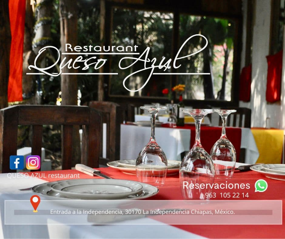 Interior de Queso Azul Restaurante con mesa puesta, vino y tabla de quesos sobre la mesa