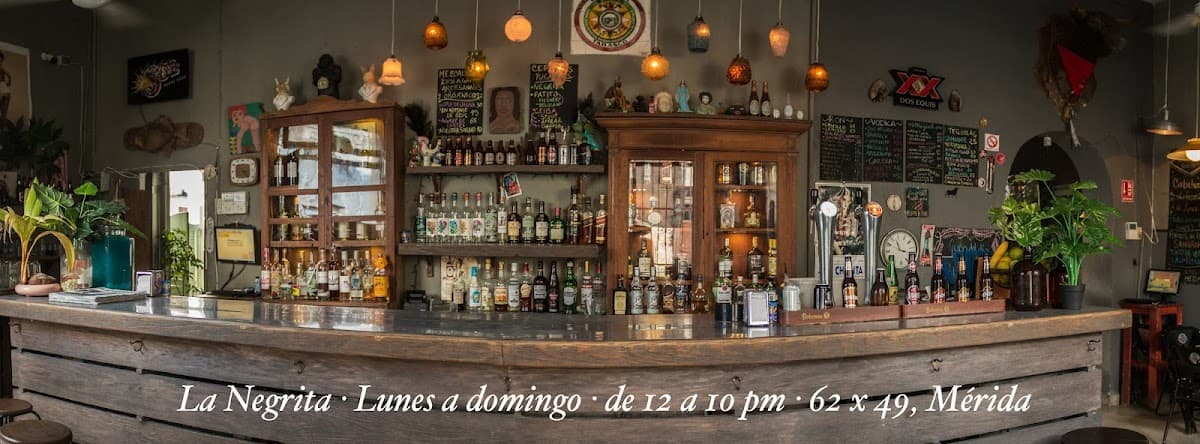 Fachada iluminada de La Negrita Cantina con neón y clientes entrando al atardecer
