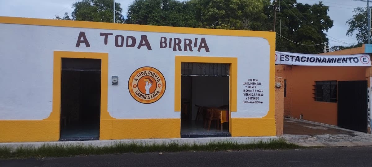 Fachada colorida de A Toda Birria en la calle 21, con su letrero y clientes en la acera