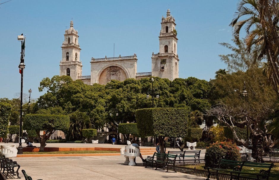 A tranquil view of Mérida's iconic cathedral from a picturesque city park.