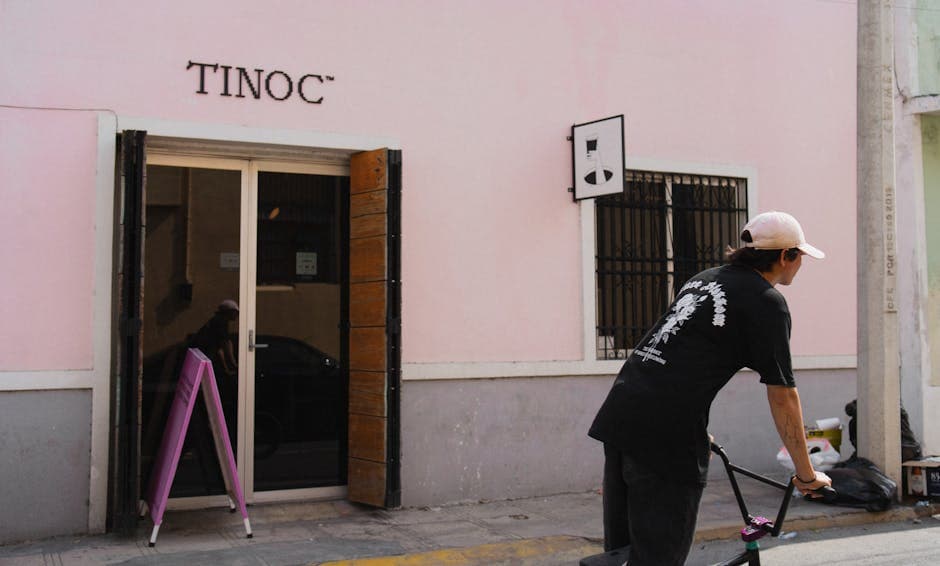 A street scene of a man on a bike near Tinoc Cafe in Merida, Mexico.