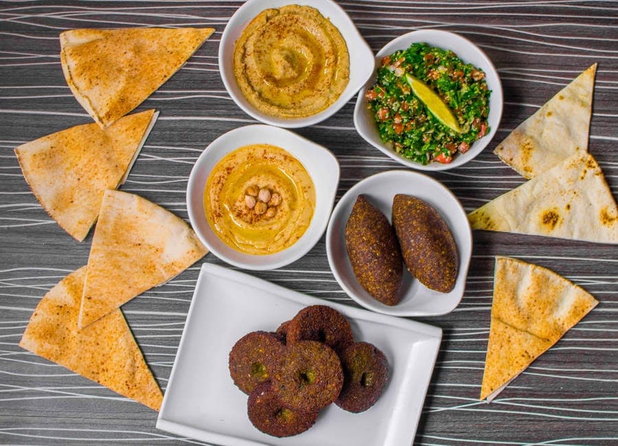 Top view of a mouthwatering Middle Eastern appetizer platter featuring hummus, falafel, and tabbouleh.