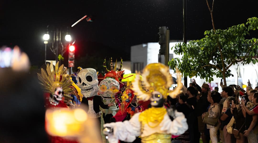 People watch a parade with skeleton costumes at night.