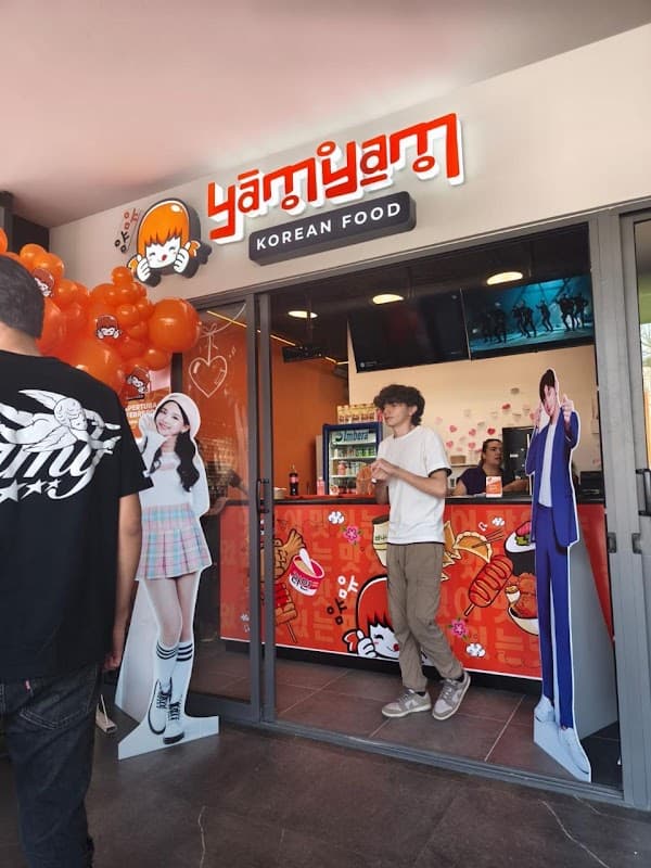 Fachada de YamYam Korean Food en Cuauhtémoc, Morelia, con letrero iluminado y clientes en la entrada