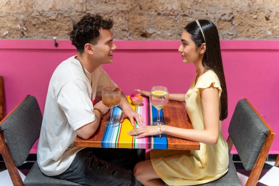 A young couple enjoying drinks at a lively restaurant with colorful decor in CDMX, Mexico.