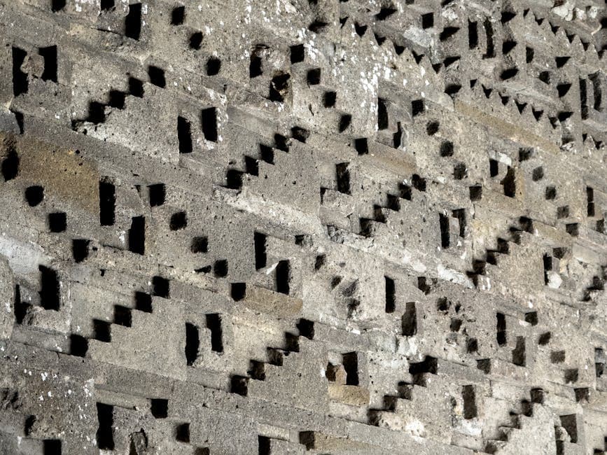 Detailed close-up of a textured stone wall with geometric patterns in Oaxaca, México.