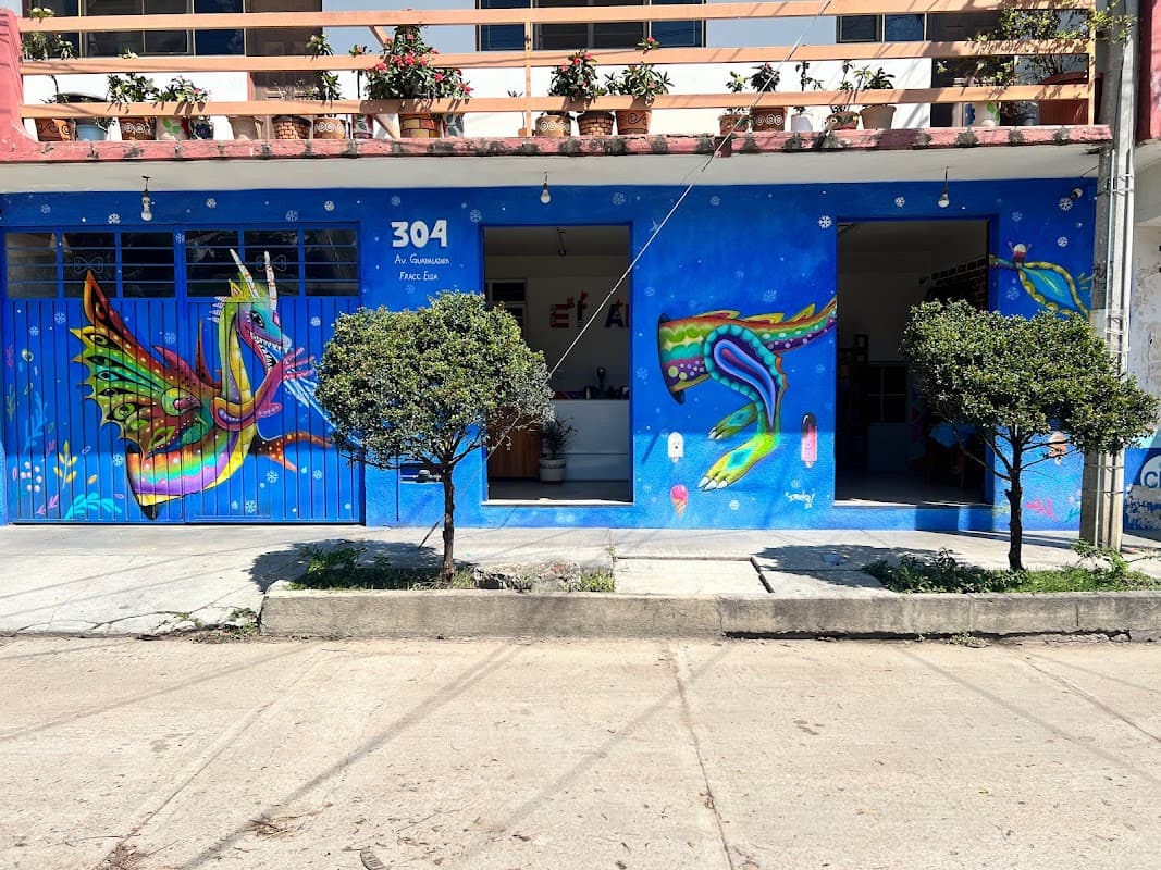 Frente colorido de Paletería el Alebrije con murales de alebrijes y clientes disfrutando paletas en la calle