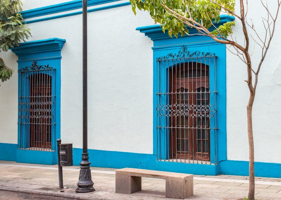Colorful colonial building facade with wrought iron windows in Oaxaca, Mexico.