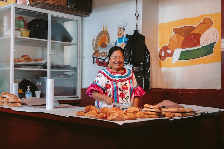 A woman in traditional dress sells freshly baked bread at a bakery in Oaxaca.