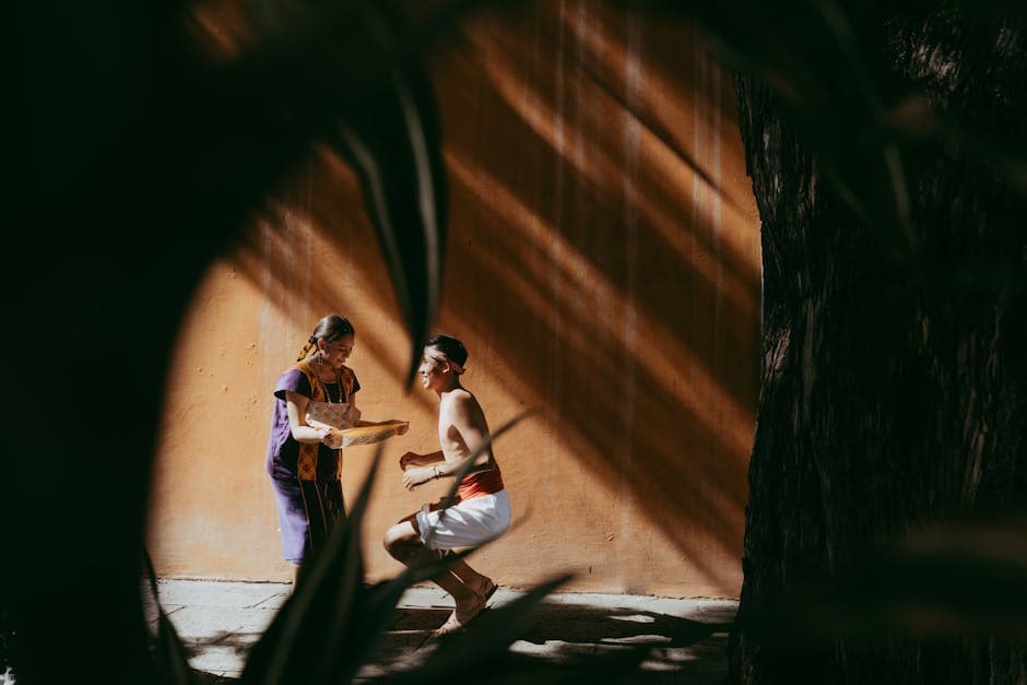 A couple performing a traditional Mexican dance outdoors in Oaxaca under dramatic sunlight.
