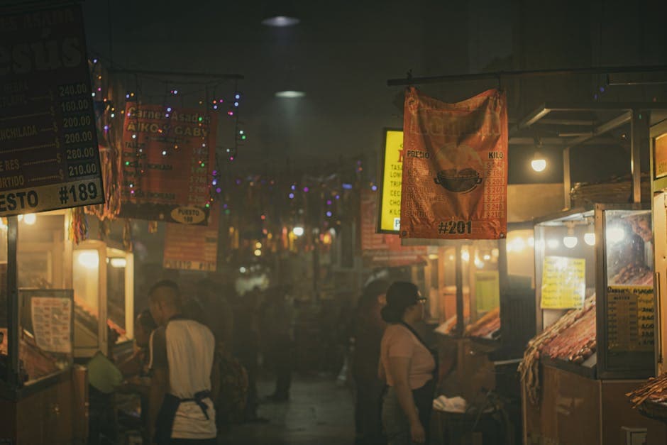 Explore the bustling ambiance of a night market in Oaxaca, Mexico, with vibrant signs and local vendors.