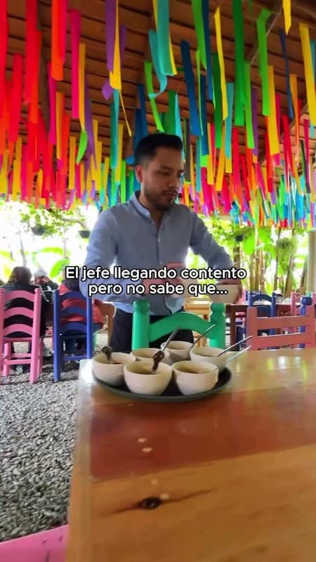 Carnes Asadas Conchita – exterior del puesto con su letrero rojo y parrilla encendida, clientes esperando para probar las tlayudas