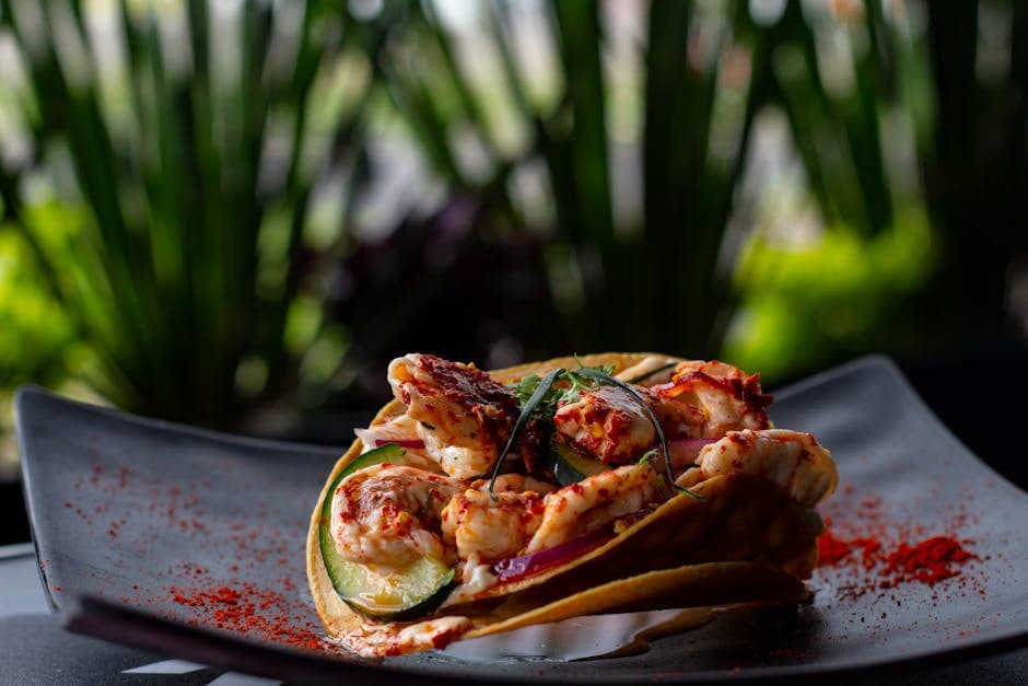 Delightful shrimp tacos with spices served on a black plate, showcasing Mexican cuisine.